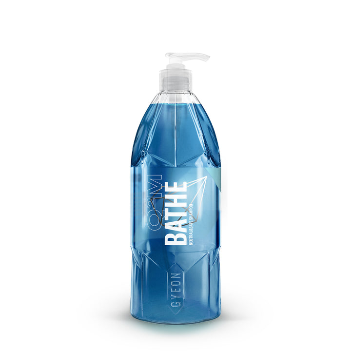 A clear bottle of Gyeon Bathe Car Wash Shampoo. Liquid is blue.